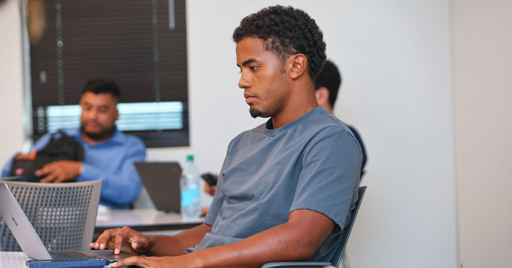 A student reviewing college ROI costs and financial aid options on a laptop.