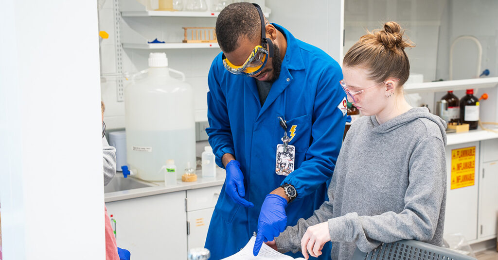Dr. Laws works in the lab with a student.