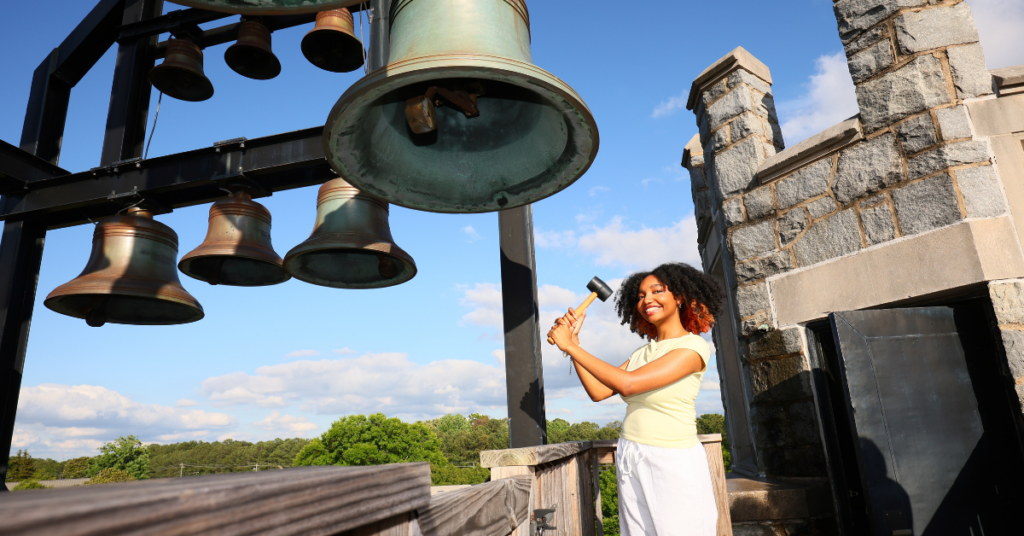 A female student rings the Carillon bell.