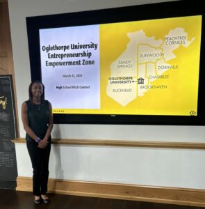 Charity Cloud in business casual attire next to a PowerPoint slide that says "Oglethorpe University Entrepreneurship Empowerment Zone.