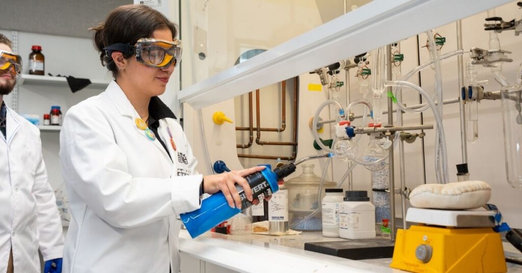 A student uses a butane torch in the lab hood.