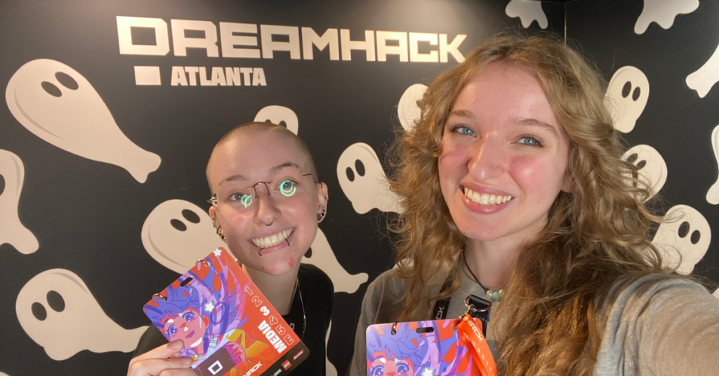 Two students from The Stormy Petrel display their press badges and smile.