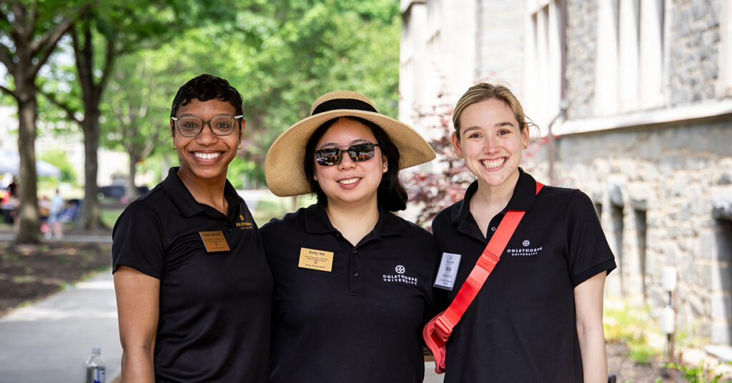 Gabbi, Emily, and Molly from the Alumni and Advancement team pose for a photo outside of Hearst Hall.