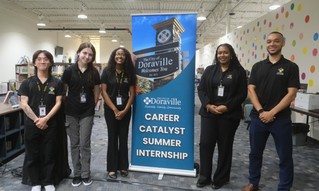Group of interns stand with City of Doraville sign
