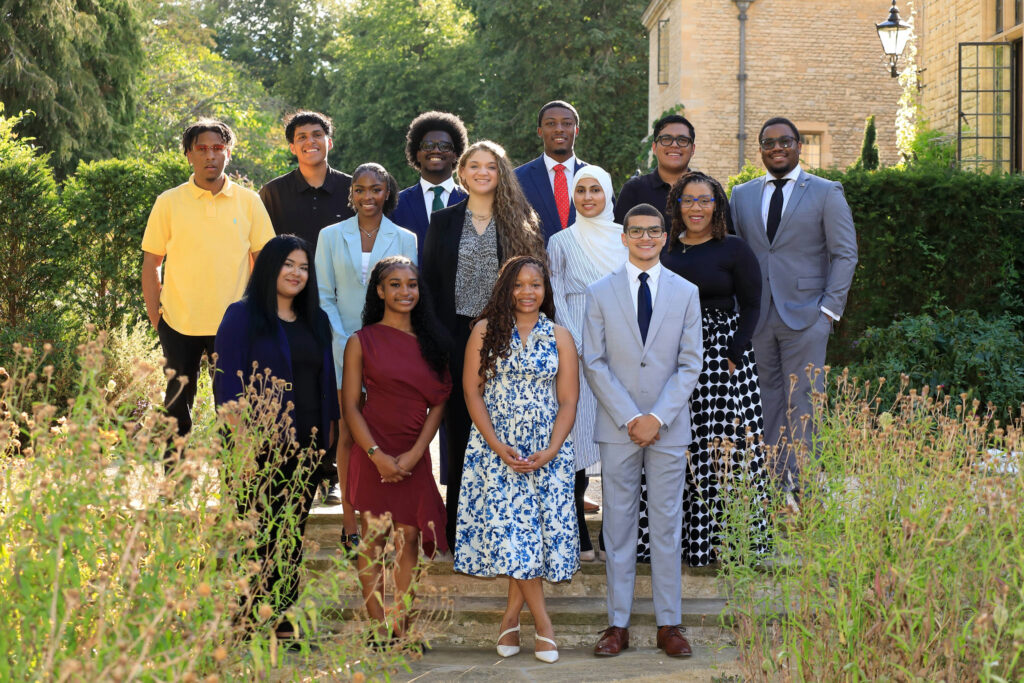 Group of students in business casual attire gathered on steps for a photo.