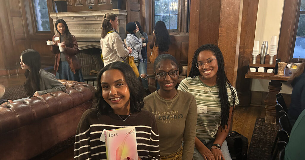 Three students sit together at a book reading event for Dr. Justin Haynes's new novel, Ibis.