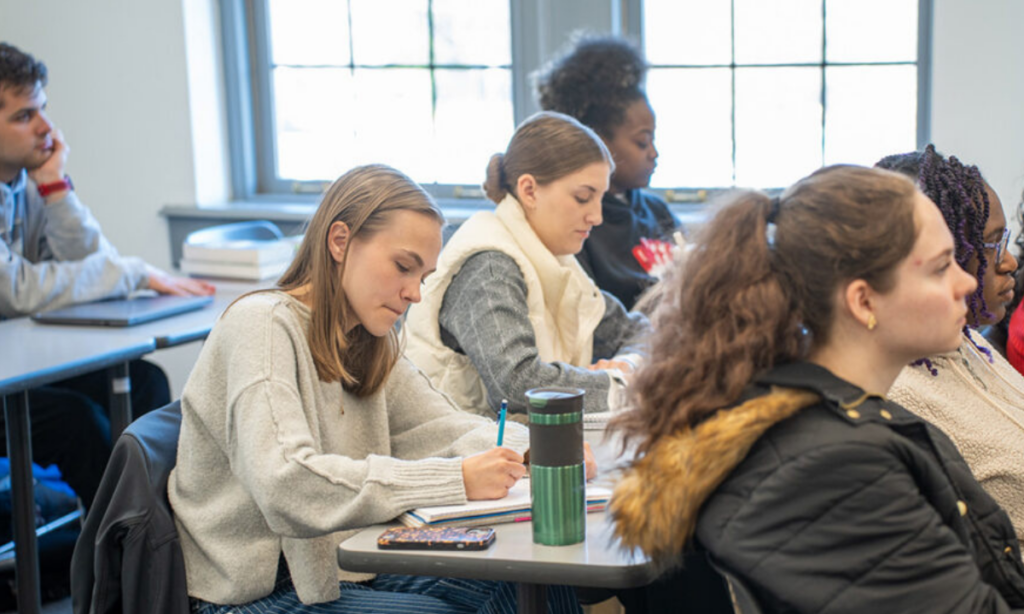 Student writes on paper.