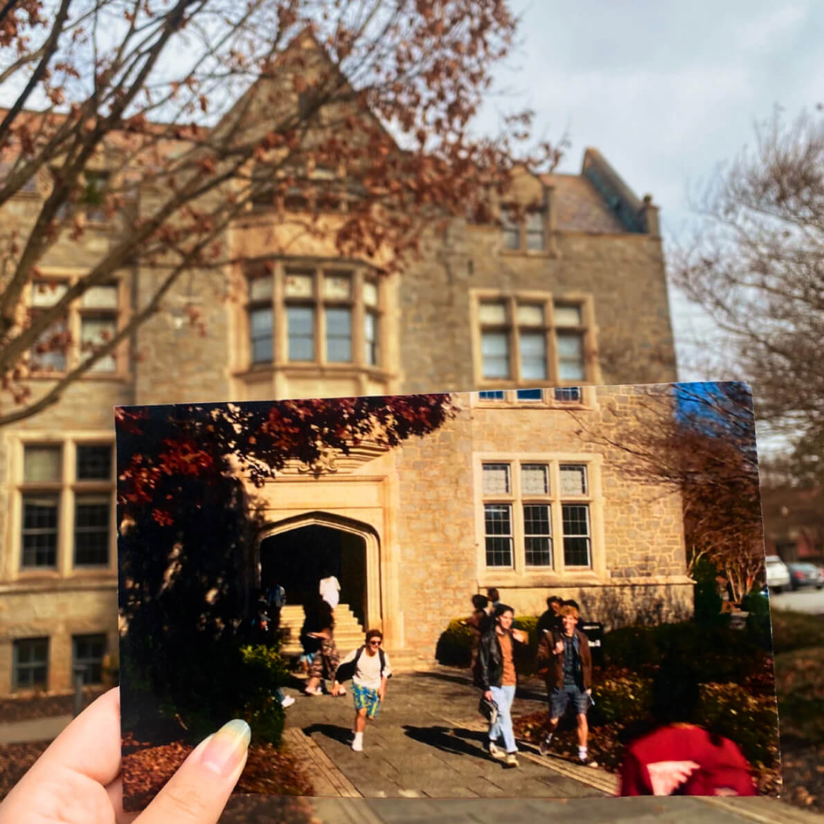 A photo from an episode of Stranger Things is held up in front of the location on campus.